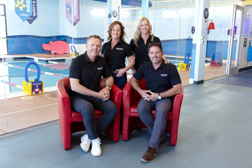 The Aqua-Tots Swim School founders in the lobby of one of their schools. Sitting in the front row are Ron Sciarro and Paul Preston. Standing in the back row is Heather Preston and Jane Sciarro.